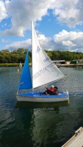 John sailing on a yacht in a lake