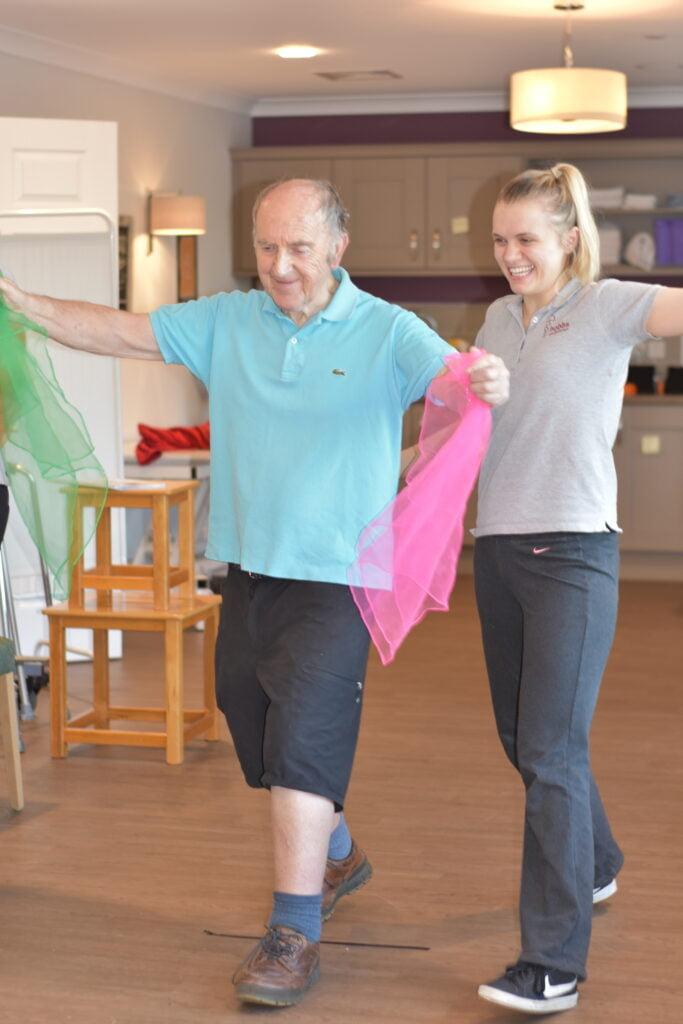 Physiotherapist assisting patient during a Parkinson's Disease (neurological conditions) exercise group activity