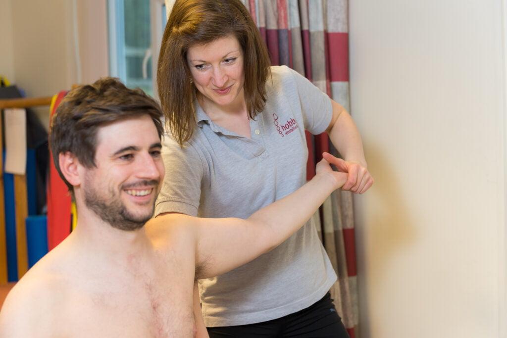 Physio stretching arm of patient in a physiotherapy session