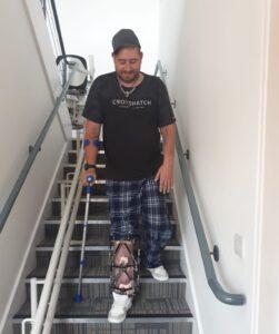 Polytrauma patient in Bristol completing therapy goal of walking down some stairs