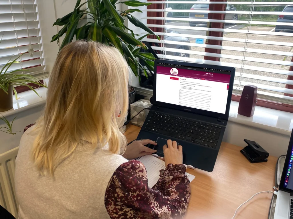 Patient entering details onto an enquiry form on a laptop